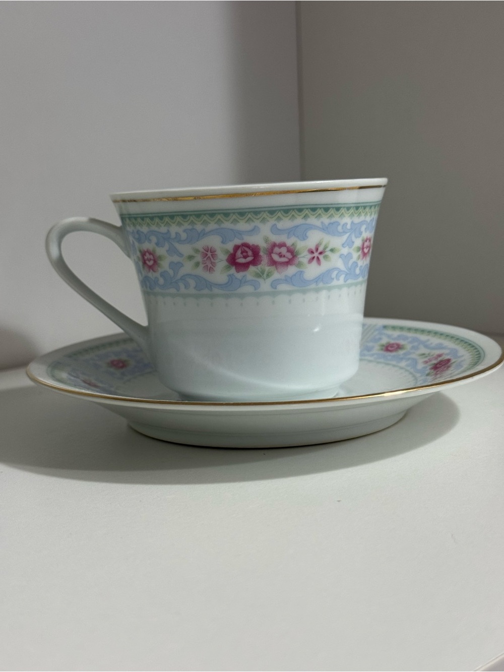 Fine Porcelain Teacup and Saucer in White with Pink Floral Border